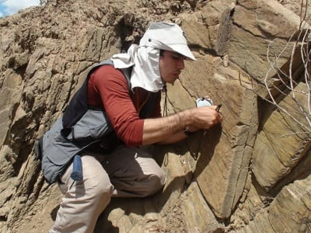 geólogo com uma bússola mapeando terreno
